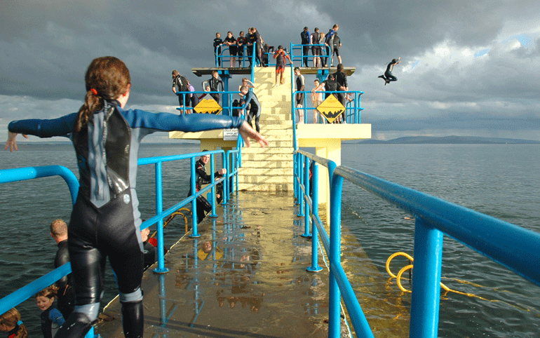 Salthill Promenade, people jumping off the Blackrock diving board at the Salthill Promenade - image Tourism Ireland