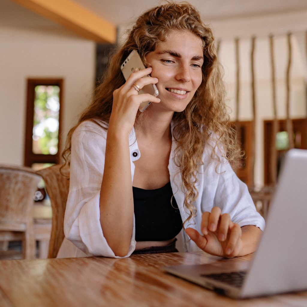 A woman with a curly hair working at her laptop - Even More Flexibility with Our Call Center